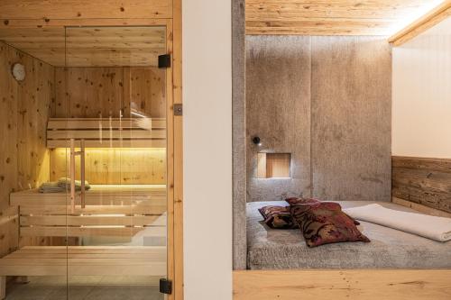 1 dormitorio con 1 cama y puerta de cristal en myLoisl Apartments, en Lutago