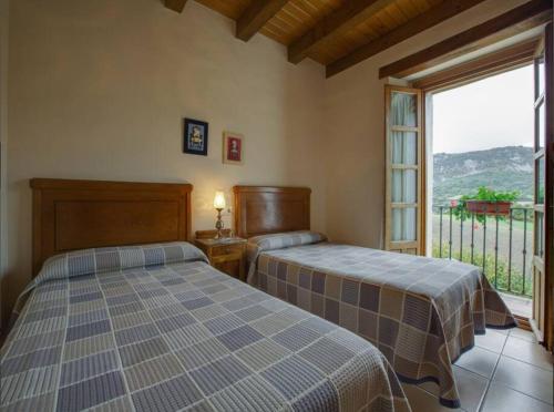 a bedroom with two beds and a large window at Casa Rural Juanbarterena in Ulzurrun