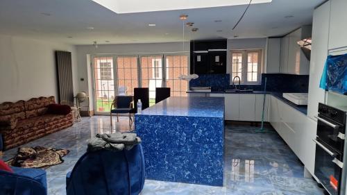 cocina y sala de estar con encimera azul en Studio Flat with kitchen and toilet included, en Dagenham