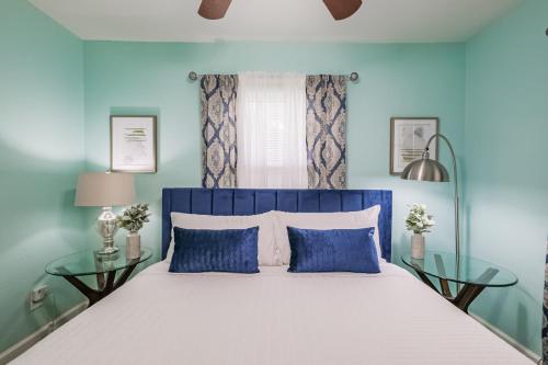 a blue bedroom with a bed and two glass tables at W 21st In The Heights, Pet Friendly, Walking in Houston
