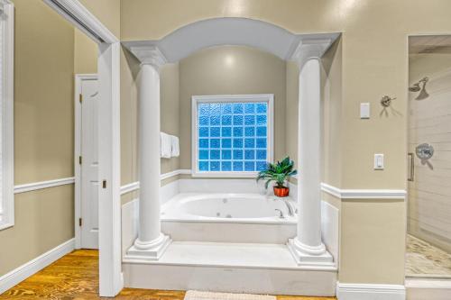 a bathroom with a tub and a window at Destiny Casa - PRIVATE HEATED POOL and 6 SEATER GOLF CART in Destin