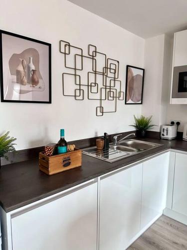 a kitchen with a sink and a counter top at Central Derby Urban 2 Bedroom Flat - An Oasis of Elegance! Free Parking and Wifi suitable for families and professionals in Derby
