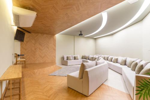 a living room with white furniture and wooden floors at Laghetto Resort Golden Oficial in Gramado