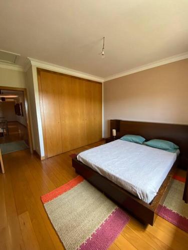 1 dormitorio con 1 cama grande y 1 alfombra en Cantinho do Minho- Ponte de Lima, en Fontão