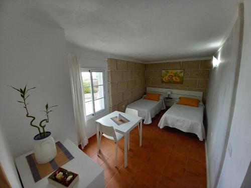 mały pokój z 2 łóżkami i stołem w obiekcie CASA ISABEL - (ZONA RURAL) w mieście Fasnia