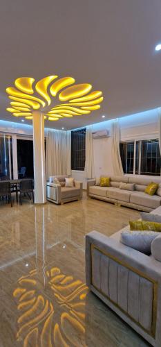 a large living room with couches and a chandelier at Villa Fares Assilah 1 in Asilah