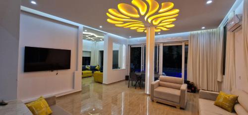a living room with a large yellow chandelier at Villa Fares Assilah 1 in Asilah