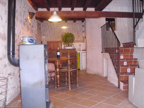 cocina con mesa y nevera en una habitación en Casa Rural con Jacuzzi Taberna del Tio Pedro, en Cabañas de Polendos