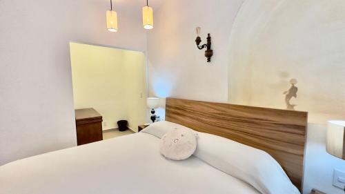 1 dormitorio con cama blanca y cabecero de madera en Casa Puerto Viejo en Puerto Escondido