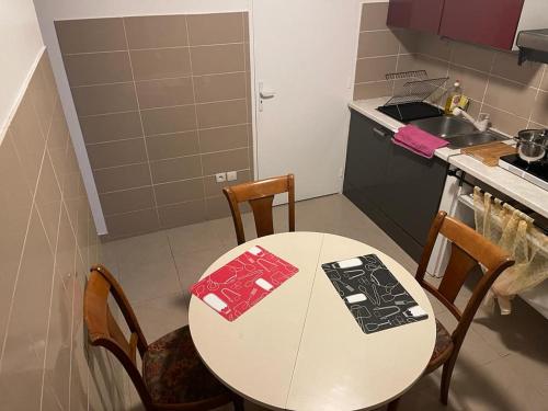 a kitchen with a white table and chairs and a sink at MAISON CHIC ET CALME in Étampes