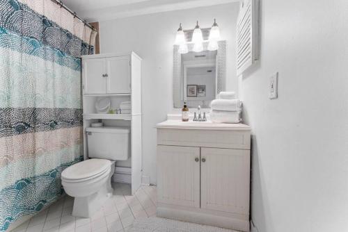 a bathroom with a toilet and a sink and a mirror at Sandpiper Oceanfront 5F in Jacksonville Beach