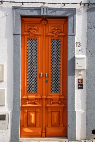 an orange door on the side of a building at Tavira Nomad Guesthouse in Tavira