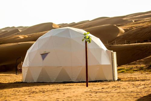 a white tent in the middle of a desert at Golden Desert Camp in Al Wāşil
