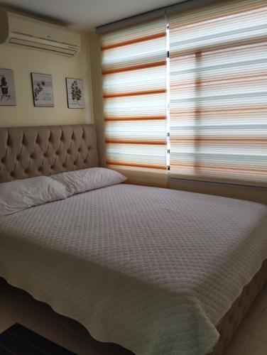 a bed in a bedroom with a window at Departamento Aventura in Manta