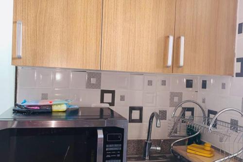 eine Küche mit einer Spüle und einer Mikrowelle in der Unterkunft Cómodo apartamento en Santiago in Licey al Medio