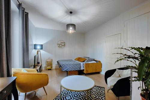 sala de estar con cama, mesa y sillas en Les Graveurs - Bourgoin-Jallieu - City Center, en Bourgoin