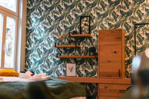 a room with a bed and a wall with a wallpaper at Gasthof Schloss Hubertus in Erfurt