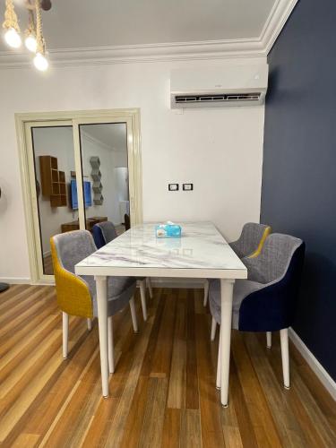 a dining room with a white table and chairs at luxury apartment at Obour, 5th floor no elevator in Cairo