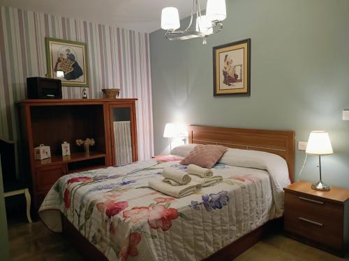 a bedroom with a bed with two towels on it at Encanto de Granada - Parking gratuito in Armilla