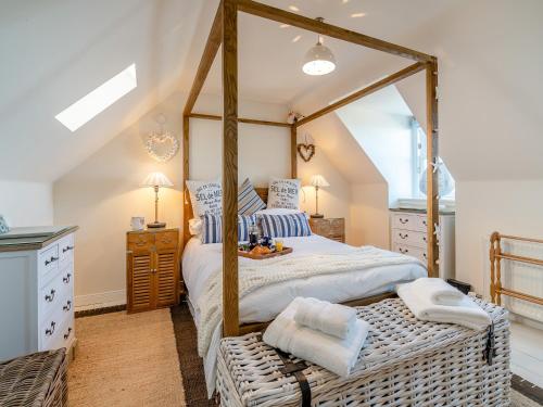 1 dormitorio con cama con dosel y marco de madera en The Old Net Shed, en Whitehills