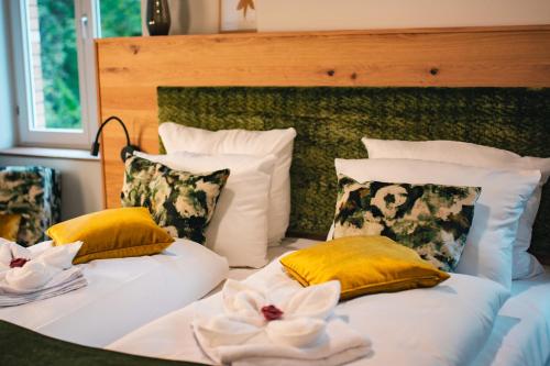 a bedroom with two beds with yellow and white pillows at Gasthof Schloss Hubertus in Erfurt
