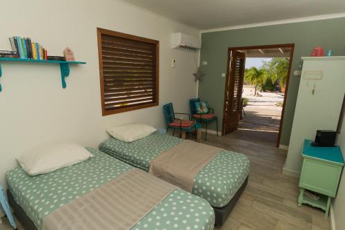 1 dormitorio con 2 camas y puerta a un patio en Kas Oleifi, een oase van rust, en Kralendijk