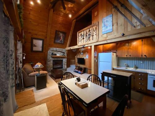 cocina y sala de estar con mesa y chimenea en U.P Norse A-frame close to Powderhorn Ski Resort, en Ironwood