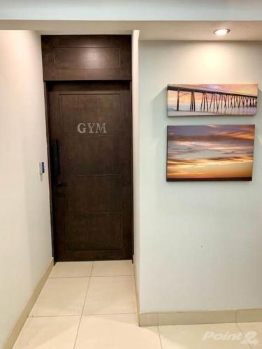a hallway with a black door and a painting at Oceana Casa Del Mar in Rosarito