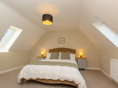 a bedroom with a large bed in a attic at The Old Laundry in Great Snoring