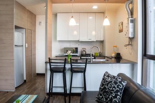 a kitchen with a counter and two bar stools at Sky Suites - Fantastic Apt in the heart of La Paz in La Paz