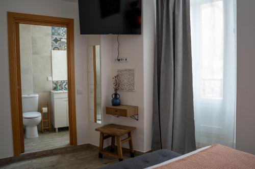 um quarto com uma casa de banho com um WC e uma janela em Tavira Nomad Guesthouse em Tavira