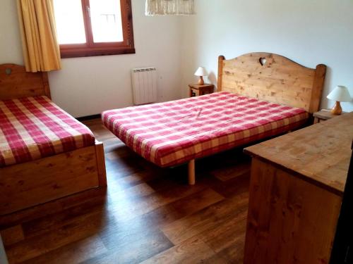 1 dormitorio con 2 camas y suelo de madera en Le Napoléon, en Lanslebourg-Mont-Cenis