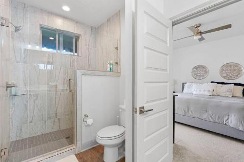 a white bathroom with a toilet and a shower at Casa Carmen by the Lakeside Golf Course in Point Venture