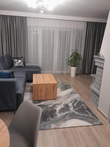 a living room with a couch and a coffee table at Domek pod Brzozami z jacuzzi ,grillem i tarasem in Przemyśl