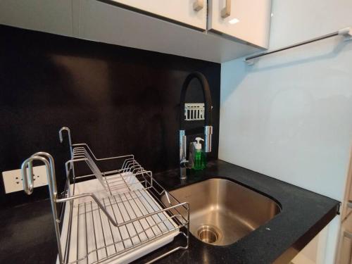 a dish drying rack next to a sink in a kitchen at Grand Avenue Pattaya in Pattaya Central