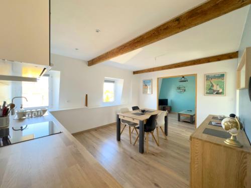 une cuisine et un salon avec une table et une salle à manger dans l'établissement Charmant appartement 2 pièces proche de la mer, à Plancoët
