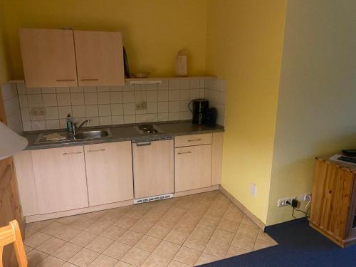 a small kitchen with white cabinets and a sink at Ferienwohnung Noack Wohnung 2 in Gablenz