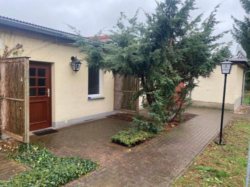 a house with a tree in front of it at Ferienwohnung Noack Wohnung 2 in Gablenz