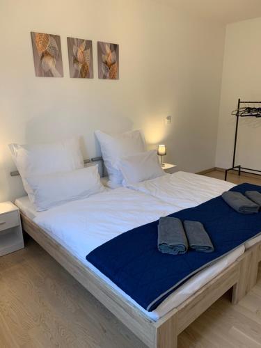 ein großes weißes Bett mit einer blauen Decke drauf in der Unterkunft Forchheim City-Zentral-Balkon in Forchheim