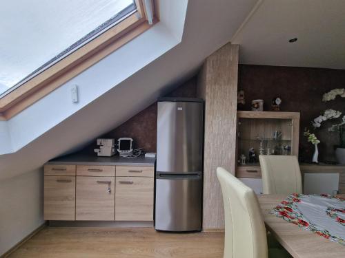 a kitchen with a stainless steel refrigerator next to a table at Cheerful Roof Flat in a Private German Style House in Mannheim