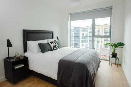 ein Schlafzimmer mit einem großen Bett und einem großen Fenster in der Unterkunft City Apartments by Dublin At Home in Dublin
