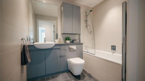 a bathroom with a toilet and a sink and a tub at City Apartments by Dublin At Home in Dublin