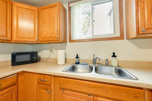 a kitchen with a sink and a microwave at Cedar Rapids Vacation Rental 2 Mi to Downtown! in Cedar Rapids