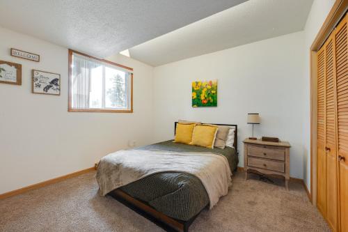een slaapkamer met een bed met gele kussens en een raam bij Cedar Rapids Vacation Rental 2 Mi to Downtown! in Cedar Rapids