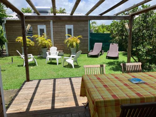 a backyard with chairs and a table and a pergola at Gîte Ty Koko in Saint-François