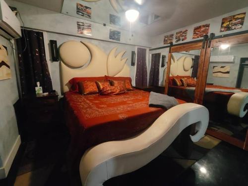 um quarto com uma cama com lençóis laranja e chifres na parede em Downtown Chop Shop house, HUGE garage pets allowed em Fort Smith