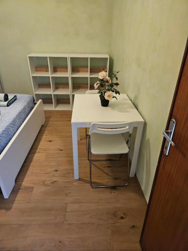 Habitación con mesa, cama y escritorio con flores. en Camera Matrimoniale, en Padua