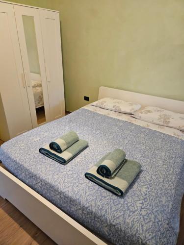 a bed with two towels and a mirror on it at Camera Matrimoniale in Padova