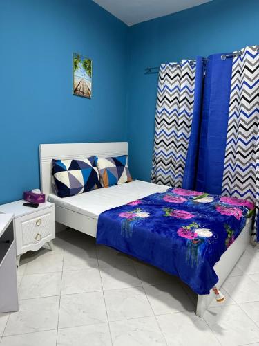 杜拜的住宿－Studio Room，一间卧室配有一张蓝色墙壁的床