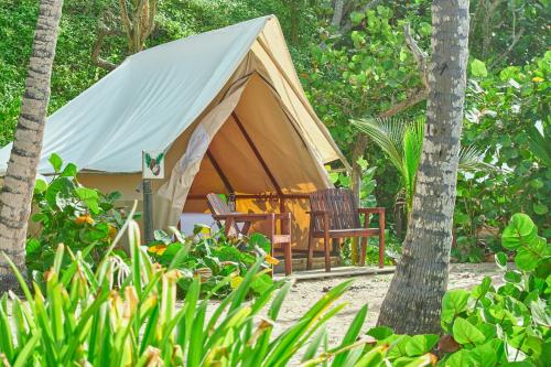 a tent with a table and chairs in a garden at Playa Los Angeles in Los Naranjos